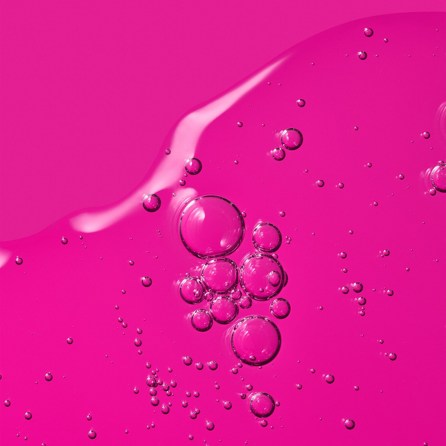 Transparent liquid with excessive bubbles over a pink background.