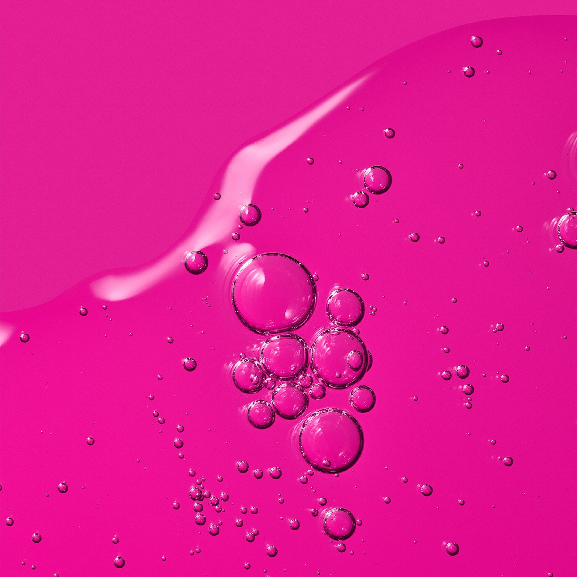 Transparent liquid with excessive bubbles over a pink background.