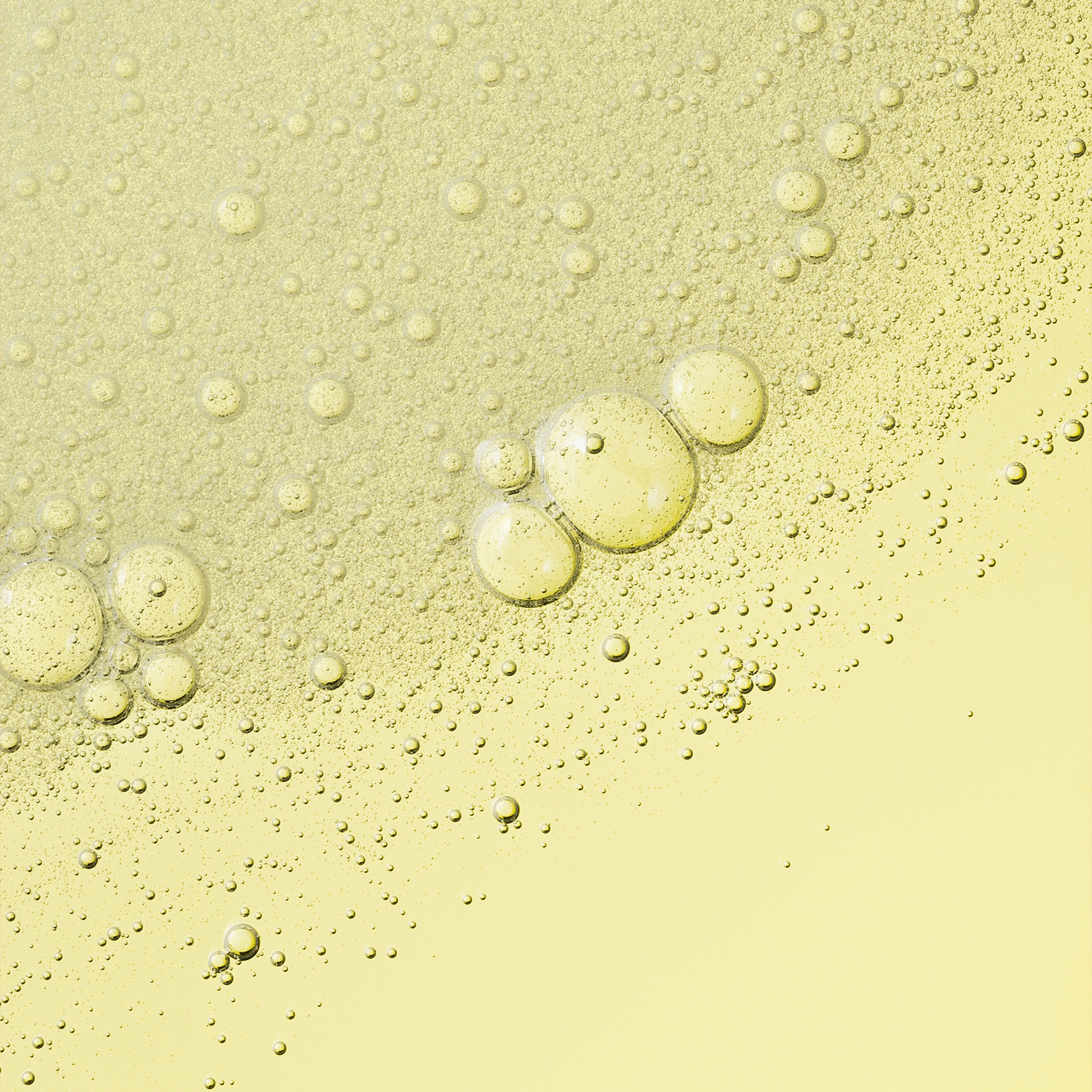 A transparent liquid with excessive bubbles on a yellow surface.