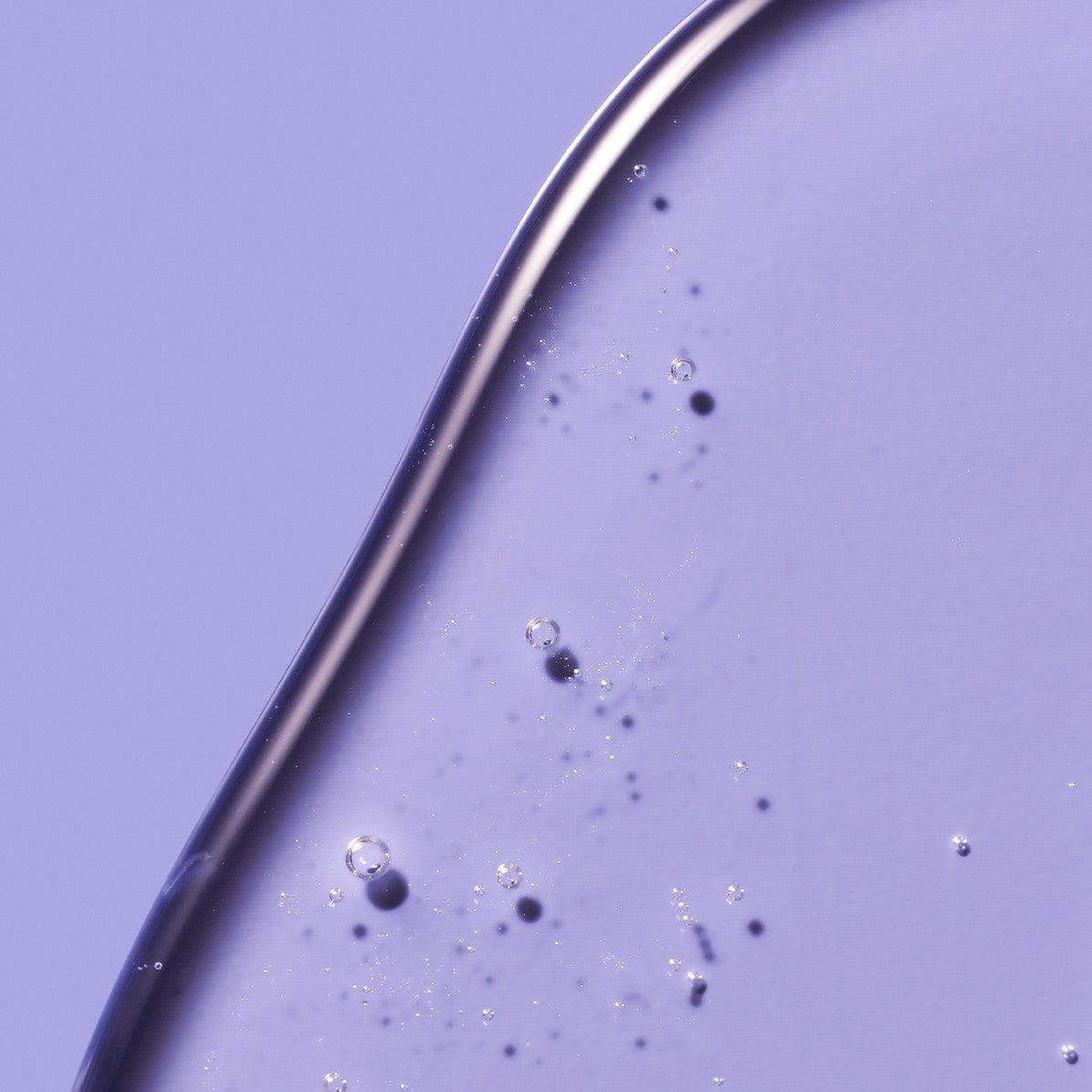 Trasparent liquid with bubbles and granules on a blue background.