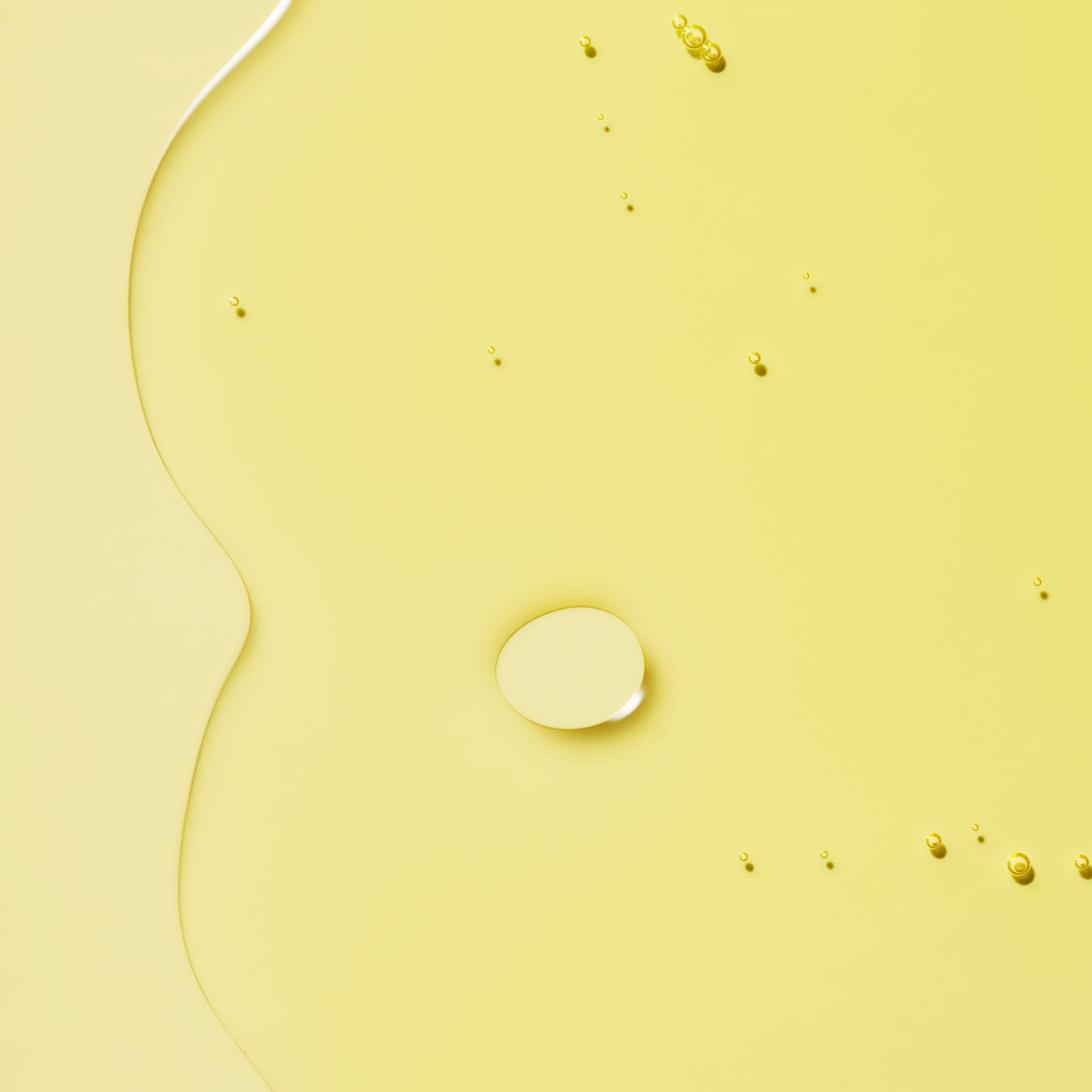 Transparent liquid with bubbles in a yellow background.