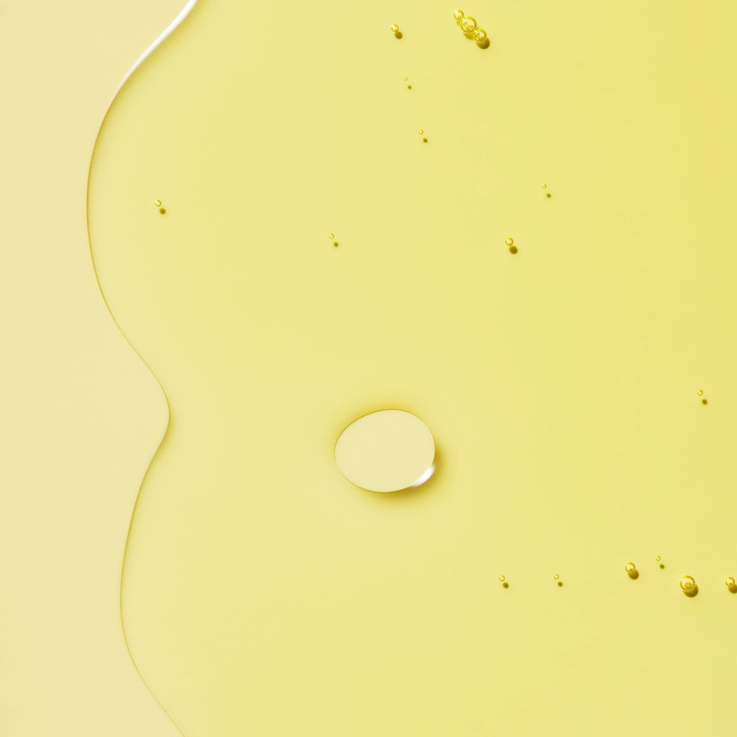 Transparent liquid with bubbles in a yellow background.
