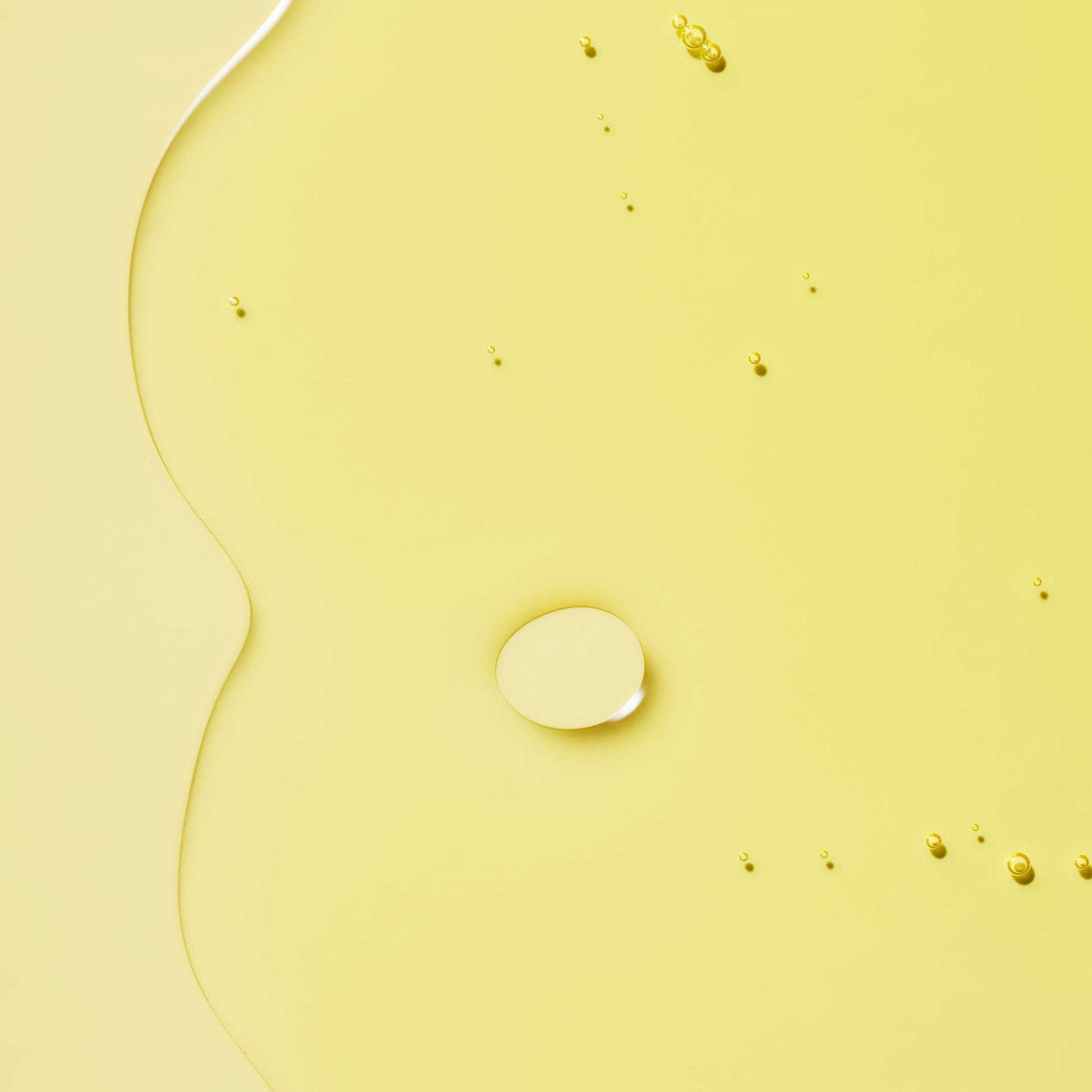 Transparent liquid with bubbles in a yellow background.