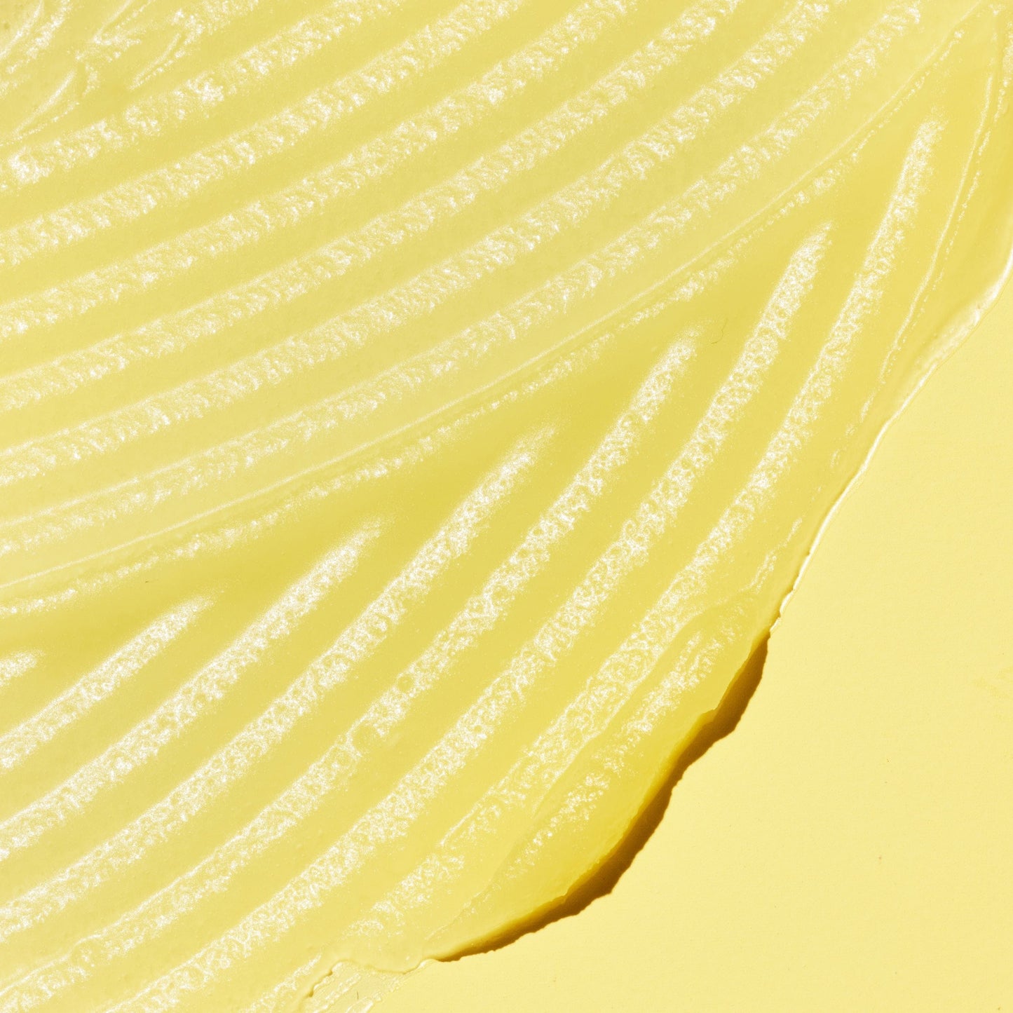 Yellow creamy lotion on a yellow surface.