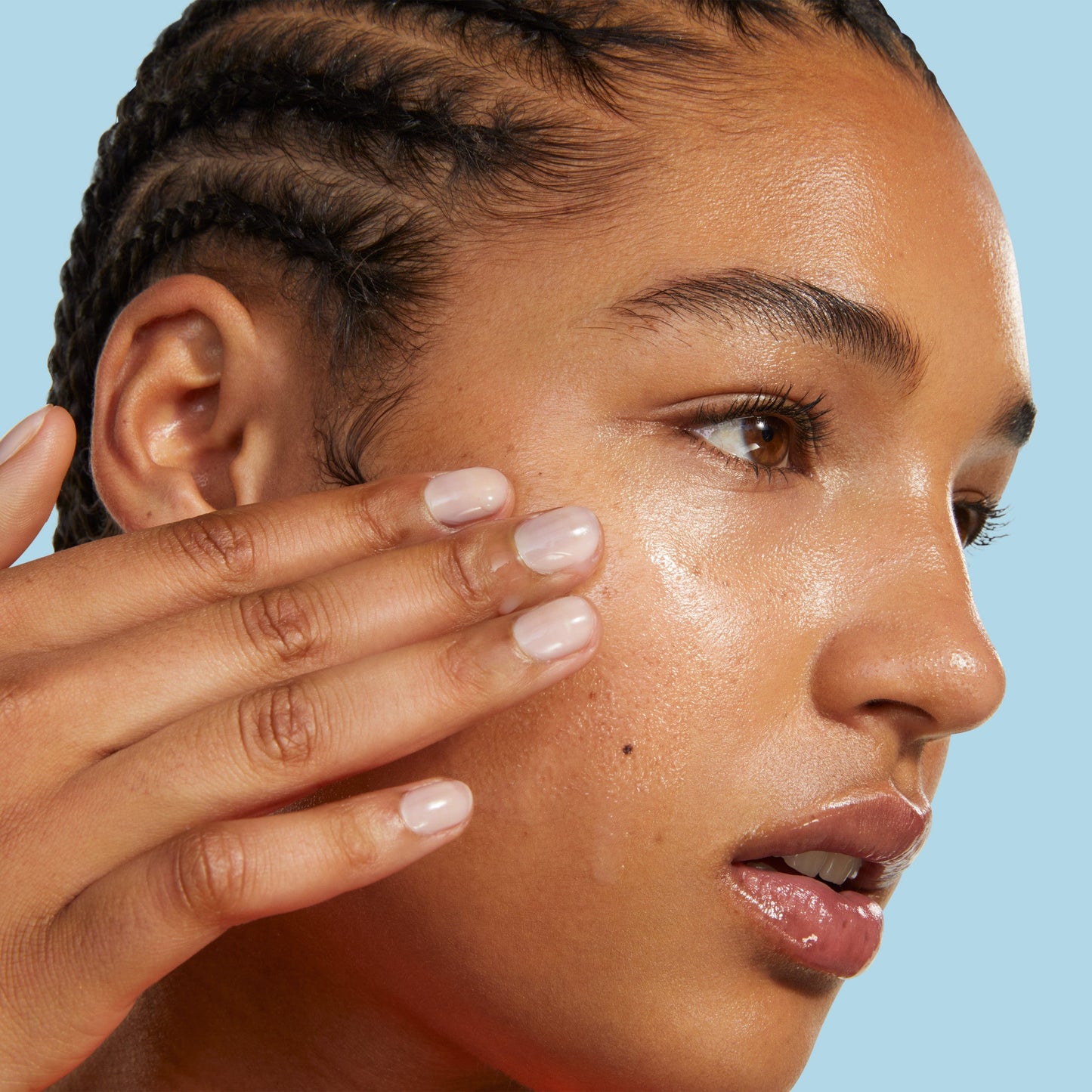 Side face of a girl with her fingers on her face.