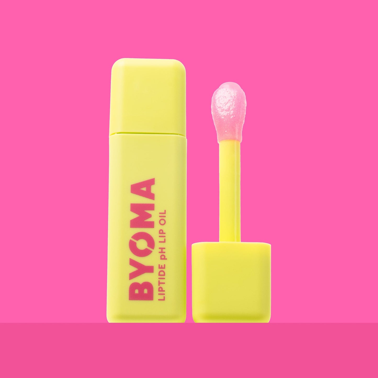 BYOMA LIPTIDE pH LIP OIL and its dispenser against a pink background.