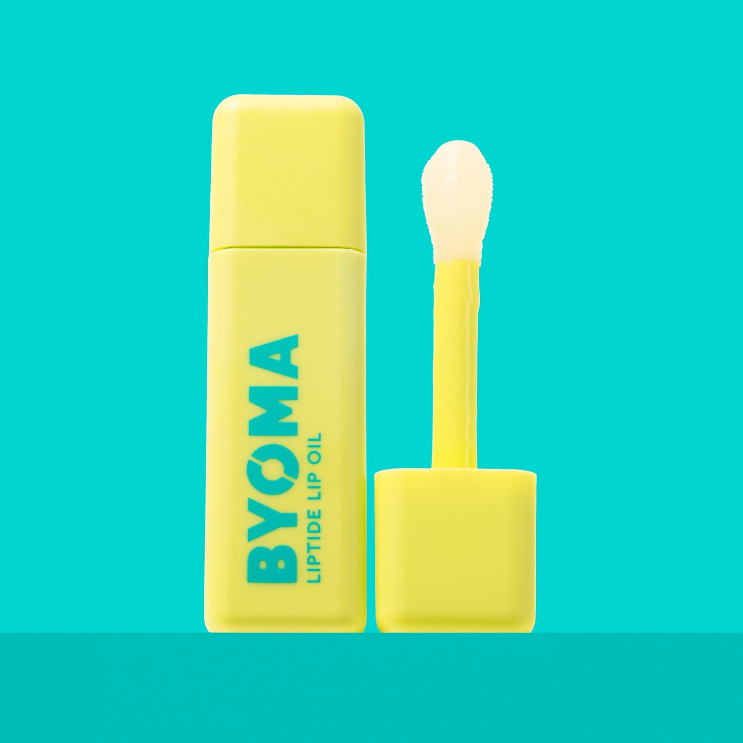 BYOMA LIPTIDE LIP OIL and its dispenser against an aqua blue background.