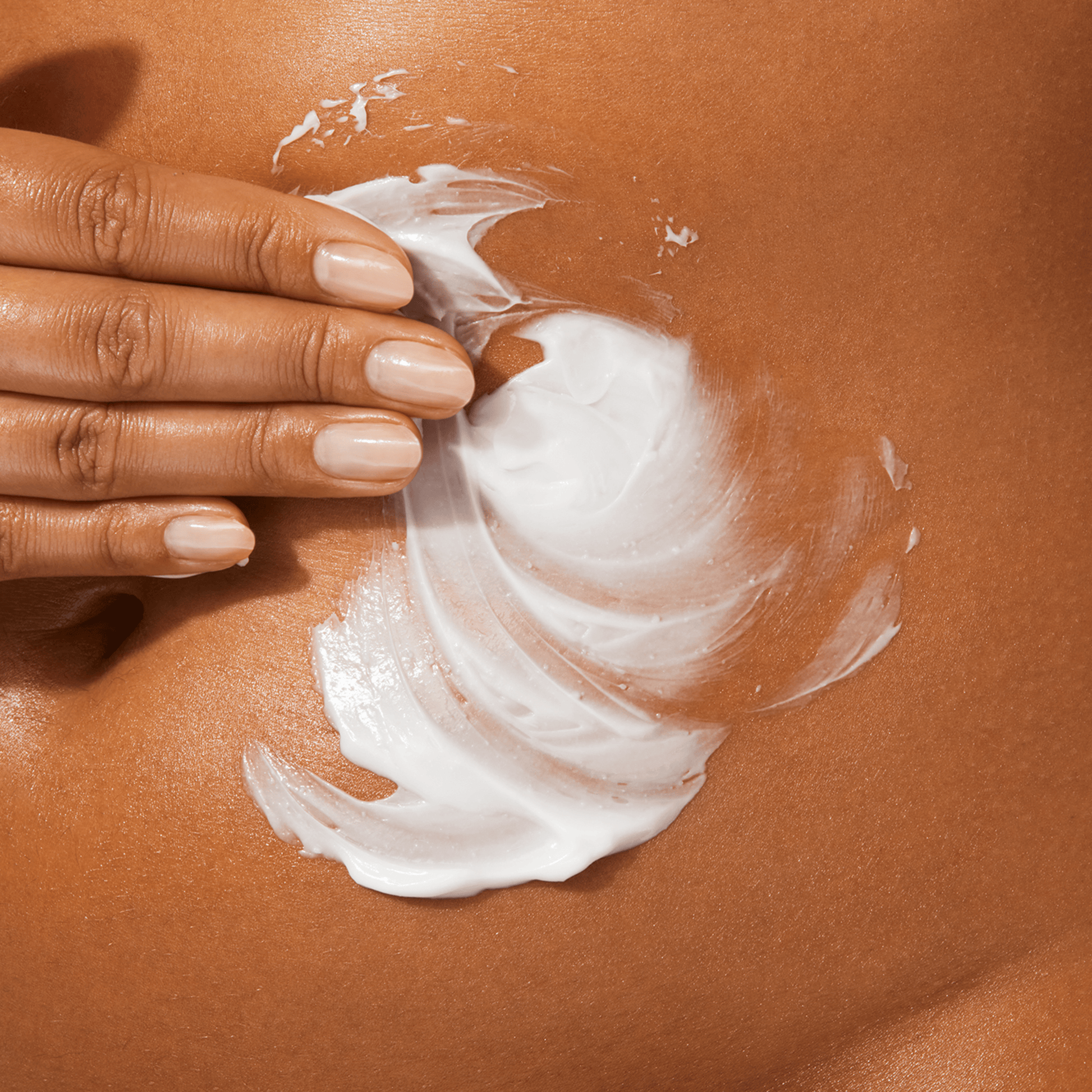 A woman applying the BYOMA cream near her navel.