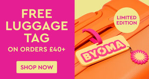 Promotional image with BYOMA luggage tag on an orange suitcase, pink background, and text about free luggage tag offer.