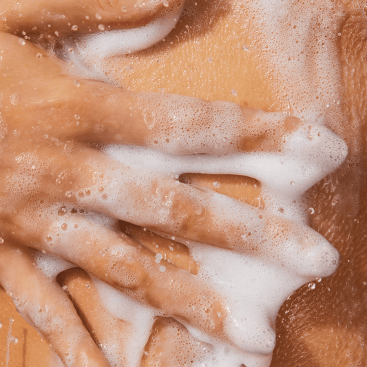 Five fingers with lather against a wet body.
